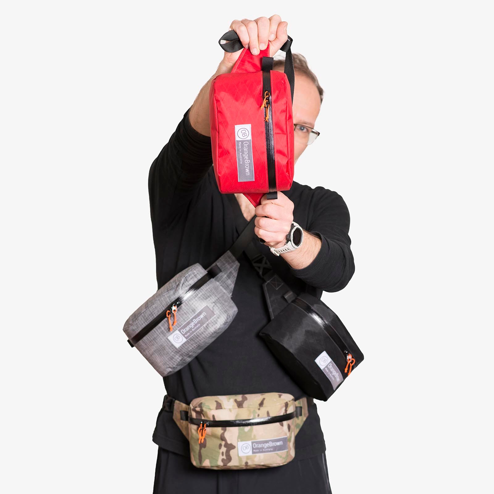 Four fanny packs for hiking and walking are held for presentation by one person. 