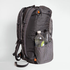 Sideview of OrangeBrown backpack OB30. The side compression cord holding down the second bottle which  is in the side pocket.
