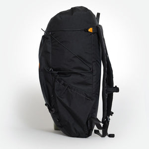 Side view of backpack OB 36 with side pocket and compression cords visible. Made from black VX21