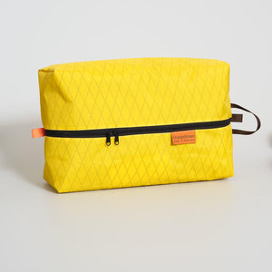 Yellow packing cell with black zipper on a light gray background