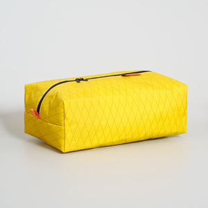 Yellow packing cubes with black zipper on a light gray background. Made from X-Pac fabric VX21 in Australia