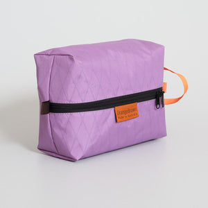 Pale purple packing cell for travel and hiking made from mulberry X-Pac fabric VX21. YKK zipper #3 with two sliders for easy opening and a webbing loop for hanging. Made in Australia.