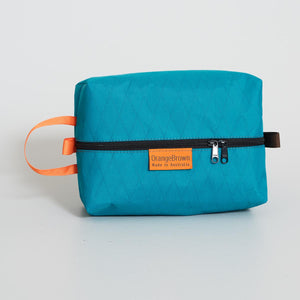 Teal coloured packing cube made from VX21 X-Pac fabric . YKK zipper #3 with two sliders for easy opening and a webbing loop for hanging. Made in Australia