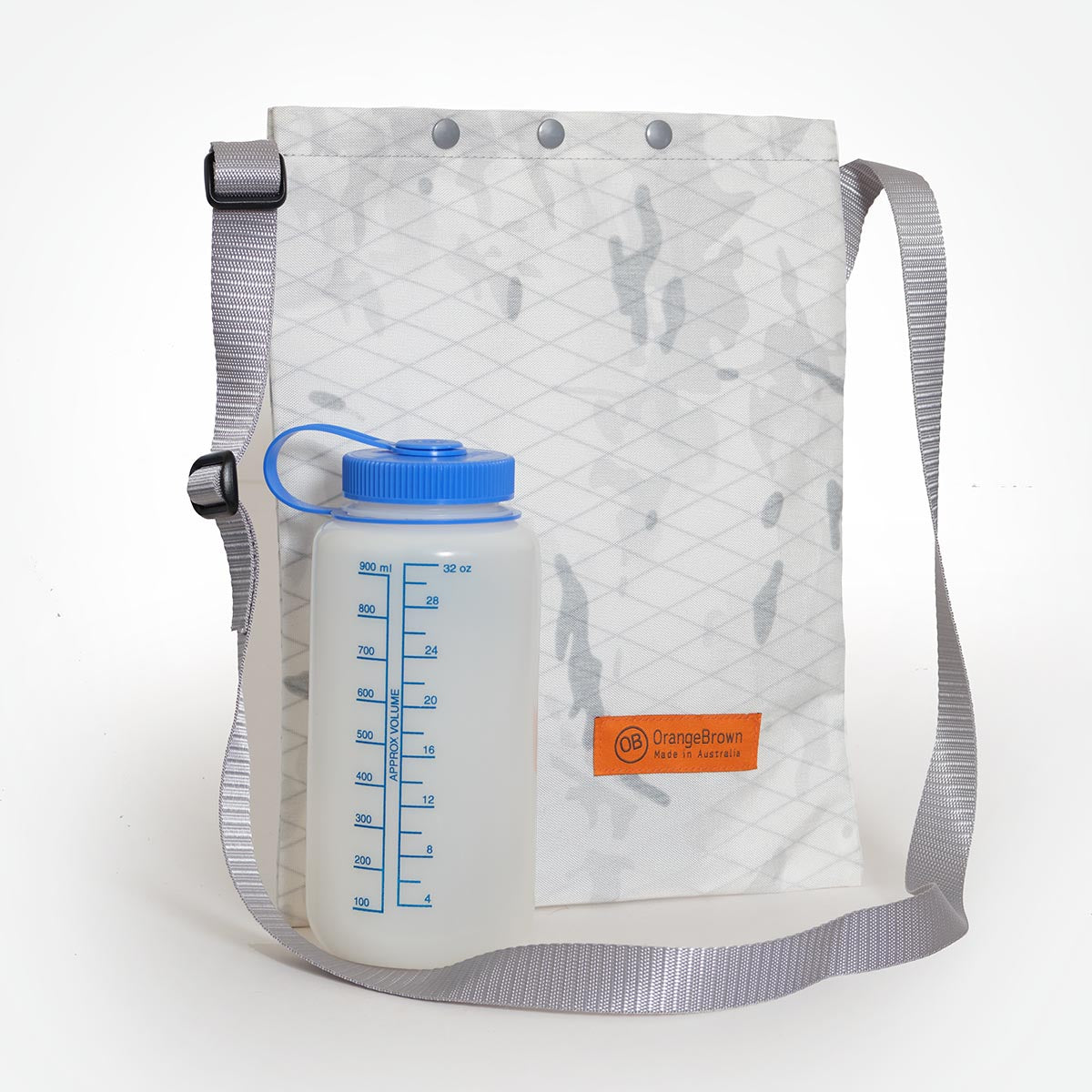 The OrangeBrown sling bag made from X-Pac X50 fabric in colour alpine camouflage with Nalgene 32oz bottle in front