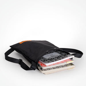 A black cross body bag made by OrangeBrown in Australia used to carry notebooks