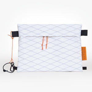 White sternum strap bag made from waterproof X-Pac VX21 fabric. Slides over the sternum strap of a backpack and is fixed to it with a short cord and mitten hook.
