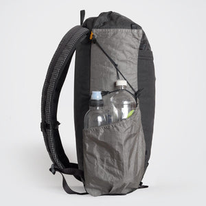 Sideview of OrangeBrown backpack OB30. The side compression cord holding down the second bottle which  is in the side pocket.