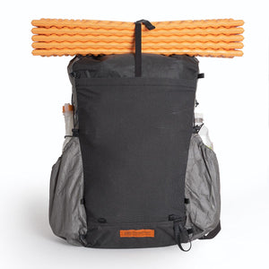 OrangeBrown backpack OB30 packed with water bottles and a water bladder in the side pockets. An orange foam mat is attached to the top with a strap.