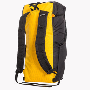 View of the shoulder straps and side pocket of a 36 L backpack. The back panel is yellow and the sides are black, both made from X-Pac fabric. 
